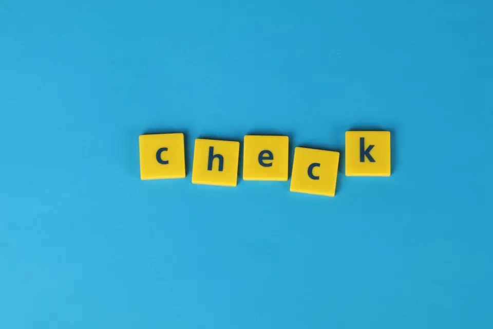 Letter tiles spelling the word 'check' on a blue background
