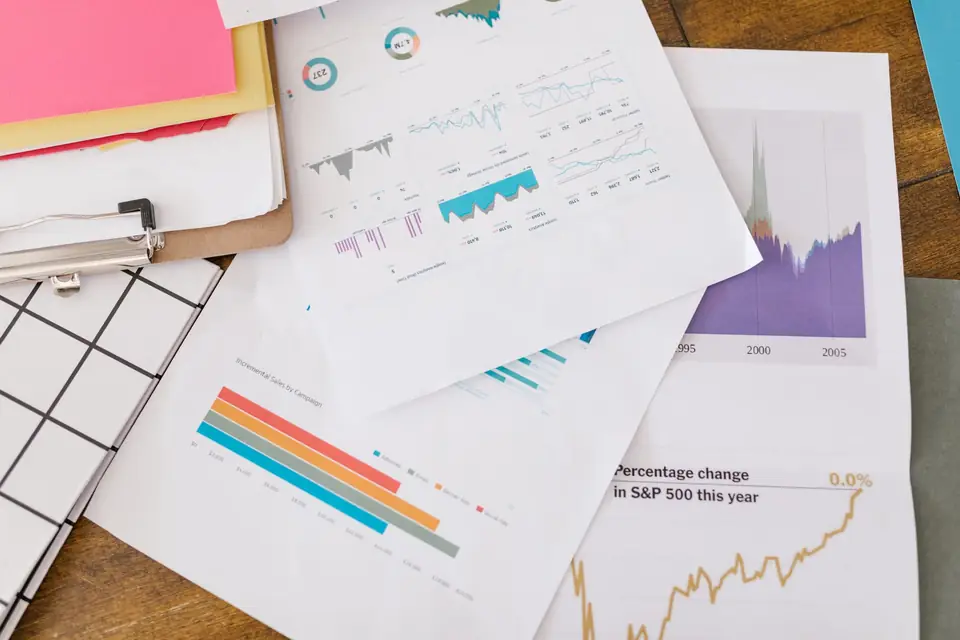 Printed analytics charts spread across a desk for a content performance review