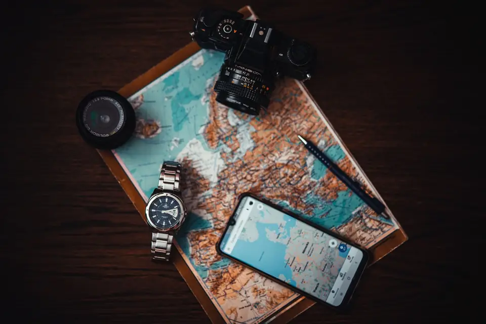Phone and camera resting on a printed world map