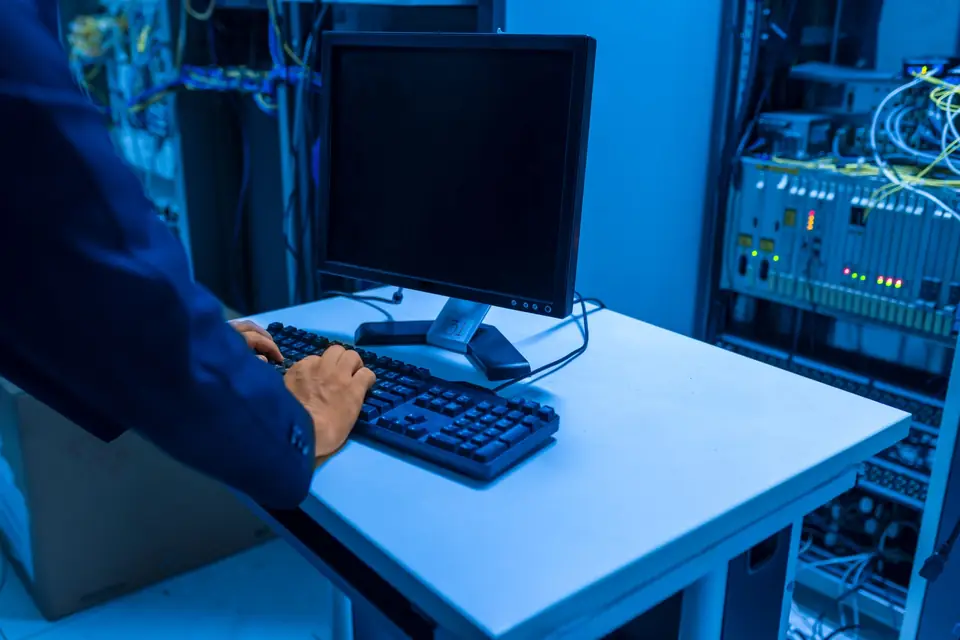 Technician working at a rack of networking equipment