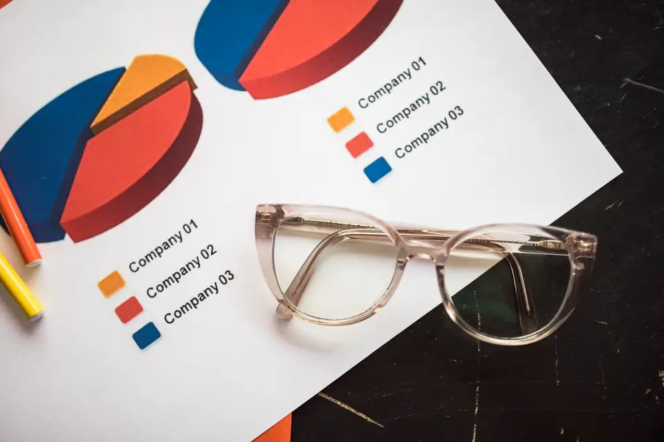 Printed comparison charts with a pair of reading glasses