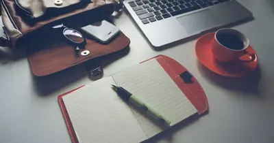 Content strategist optimising a page draft at a workspace with notes and laptop