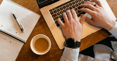 Writer drafting a long-form SEO article on a laptop