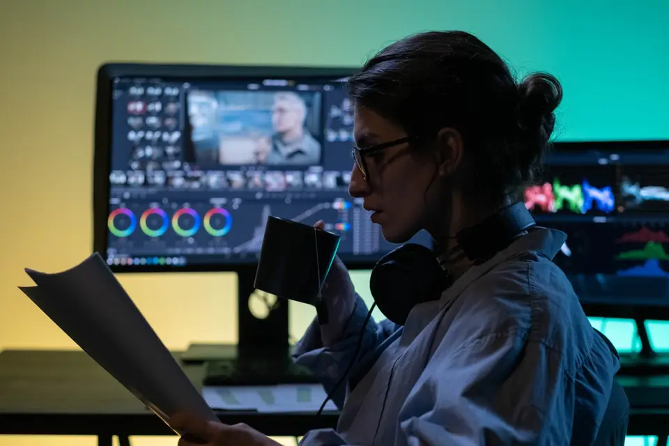 Editor at a production workstation reviewing content before it ships