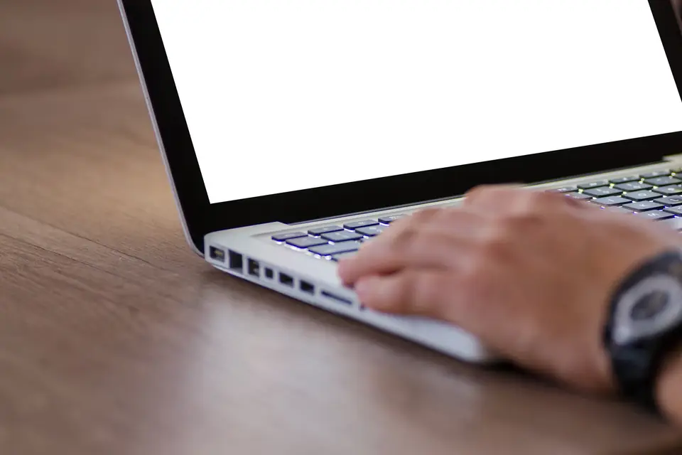 Working at a laptop while reviewing competing pages